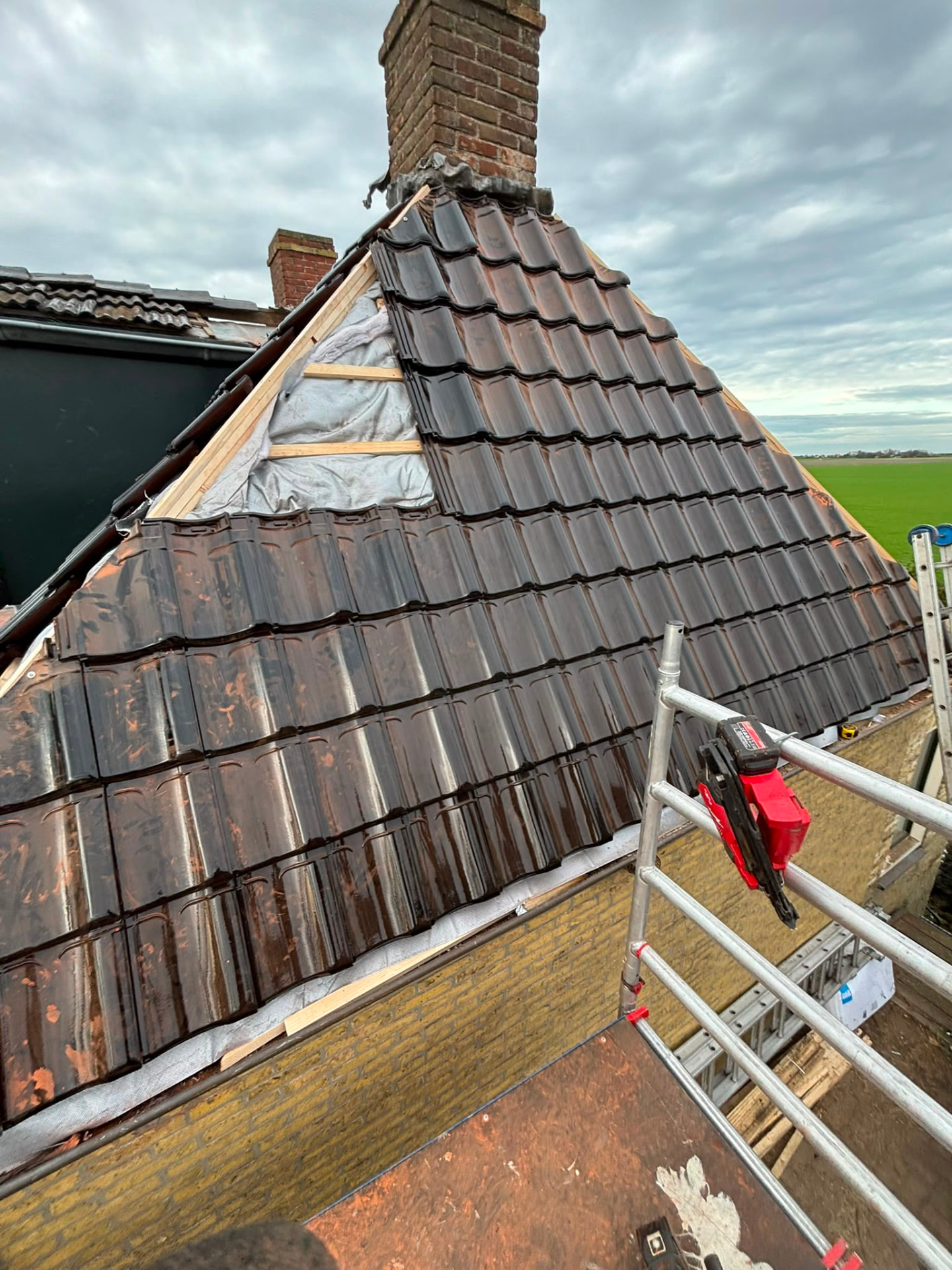 Verweerd pannendak met metselwerk schoorsteen vóór herstel